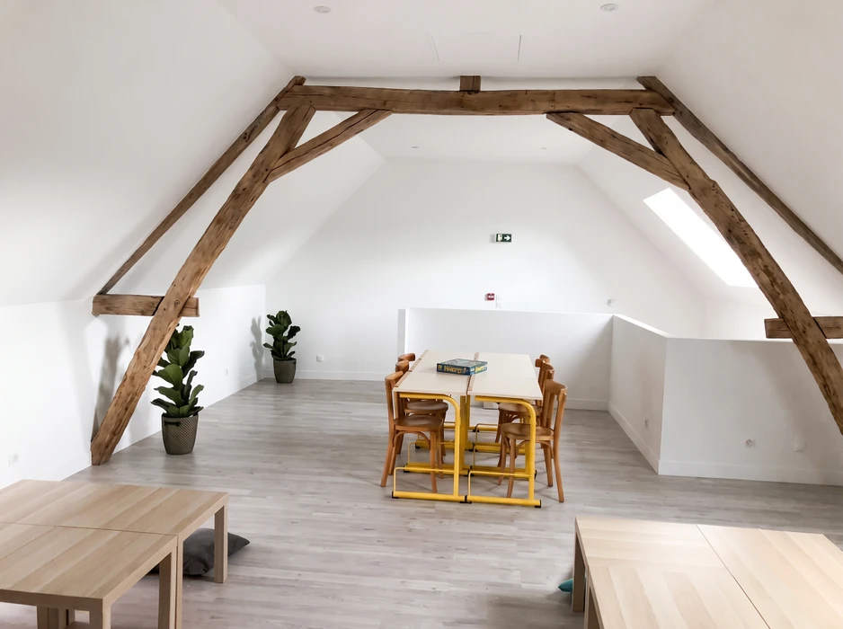 Espace de travail collaboratif aménagé dans des combles rénovés